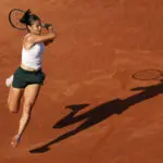 Emma Raducanu hits a forehand shot on a clay court.