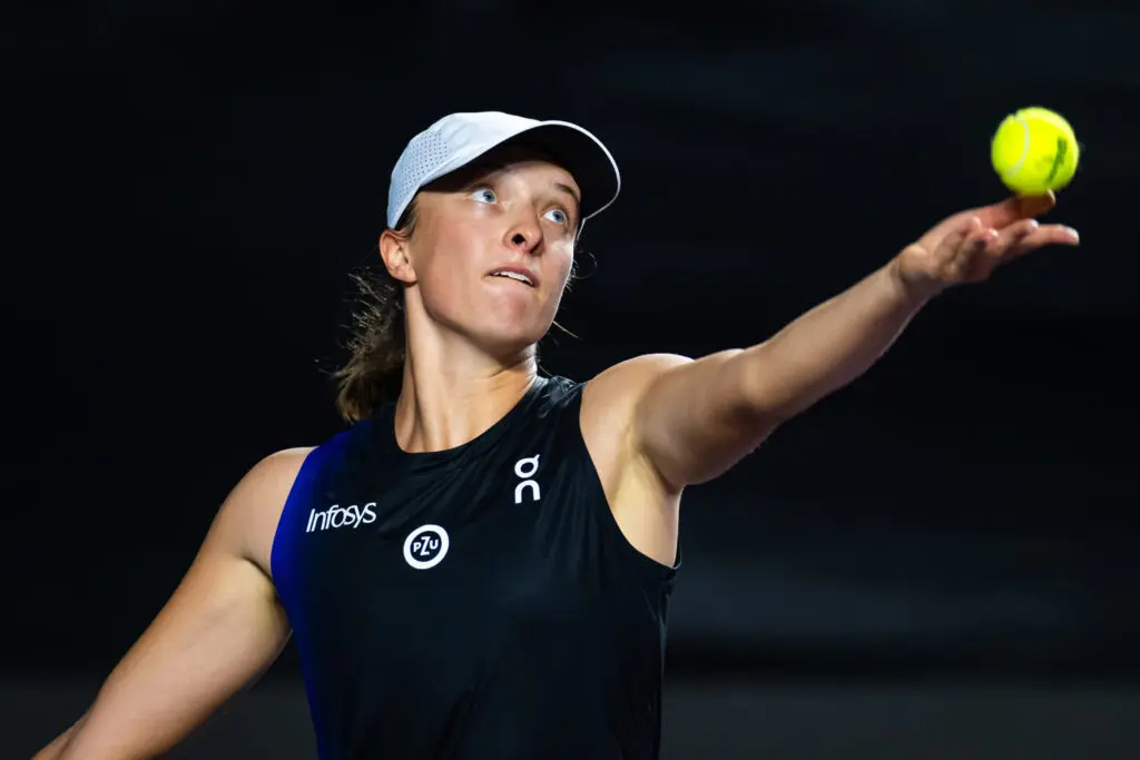 Iga Swiatek serves against Coco Gauff during the group stage of the 2023 WTA Finals in Cancun, Mexico