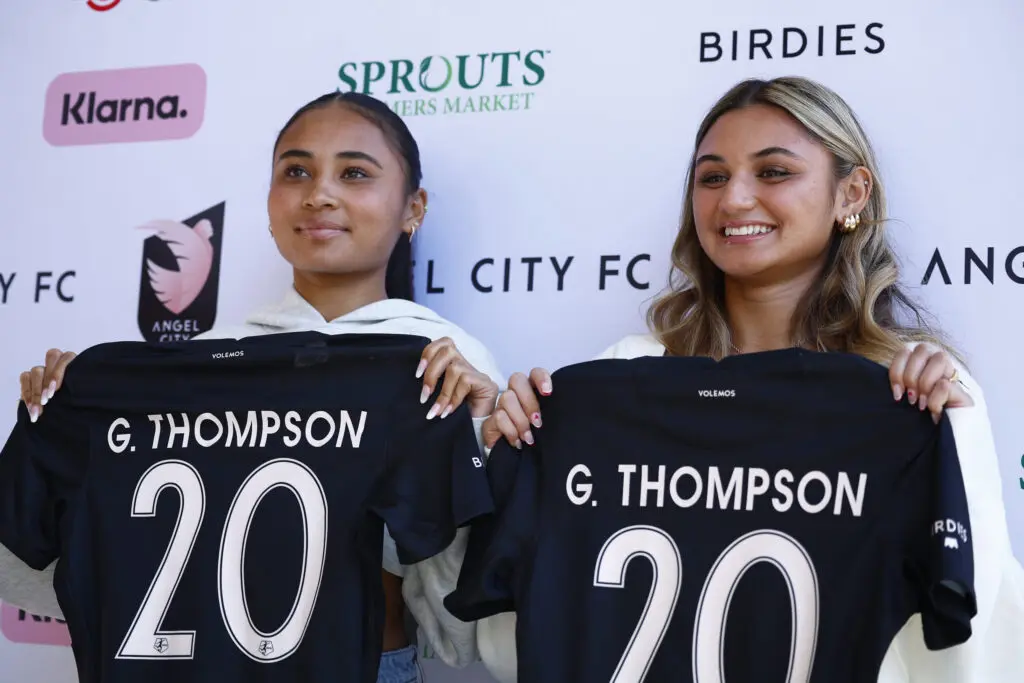 Alyssa Thompson and Gisele Thompson of Angel City FC hold up their NWSL jerseys.