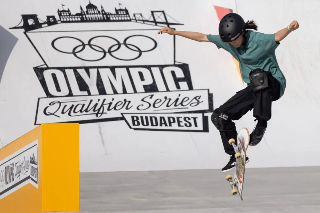 Japan's Coco Yoshizawa kick-flips her skateboard at the 2024 Olympic street qualifier