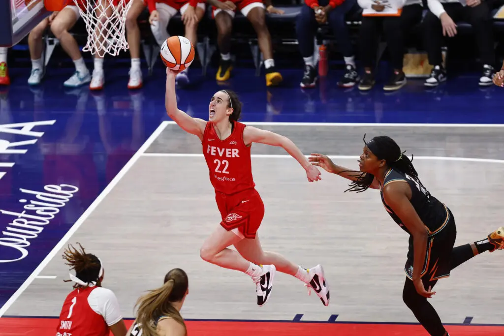 wnba rookie Caitlin Clark drives past New York Liberty forward Jonquel Jones
