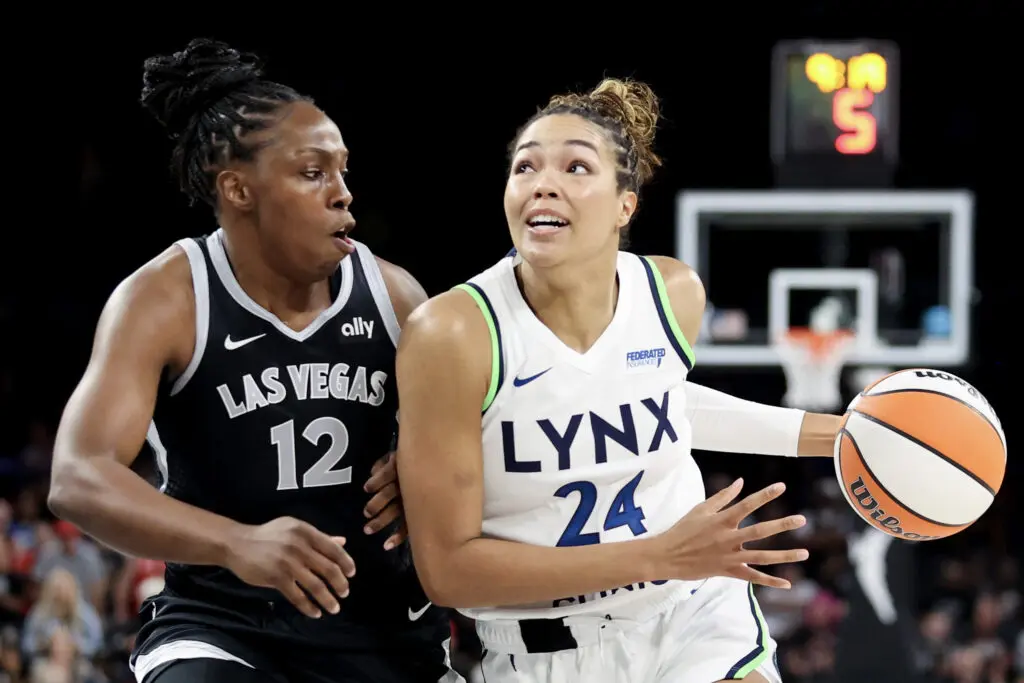 Minnesota Lynx player Napheesa Collier drives past Las Vegas Aces Chelsea Grey in a WNBA game