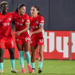 Kansas City Current midfielder Debinha (99) celebrates with forward Temwa Chawinga (6) and midfielder Lo'eau LaBonta (10) after scoring against the North Carolina Courage during the match at CPKC Stadium.