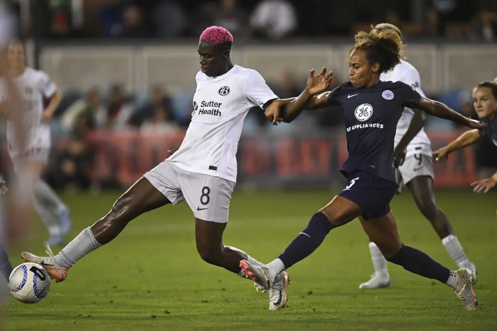 Bay's Asisat Oshoala dribbles past Louisville's Ellie Jean during an NWSL match.