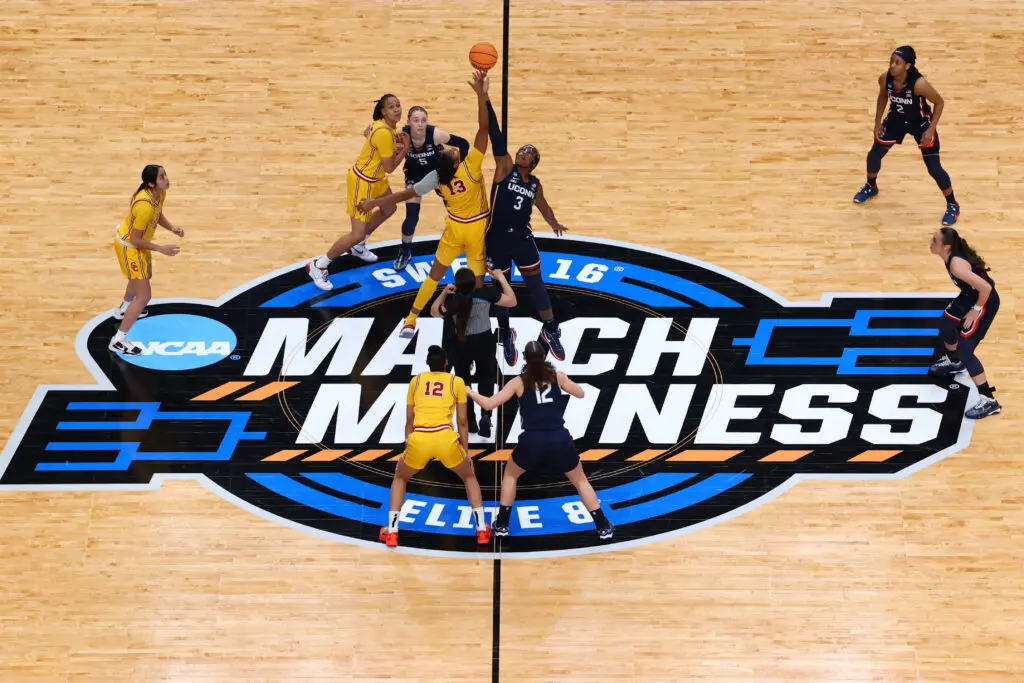 The USC Trojans and the UConn Huskies jump for the opening tip off during the Elite Eight round of the 2024 NCAA Women's March Madness Tournament held at the Moda Center on April 1, 2024 in Portland, Oregon. 