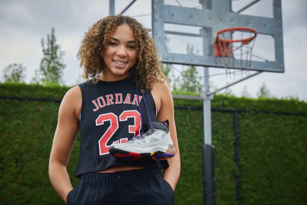 March Madness UCLA star Kiki Rice models Nike sneakers on an outdoor basketball court for her Jordan brand NIL deal.
