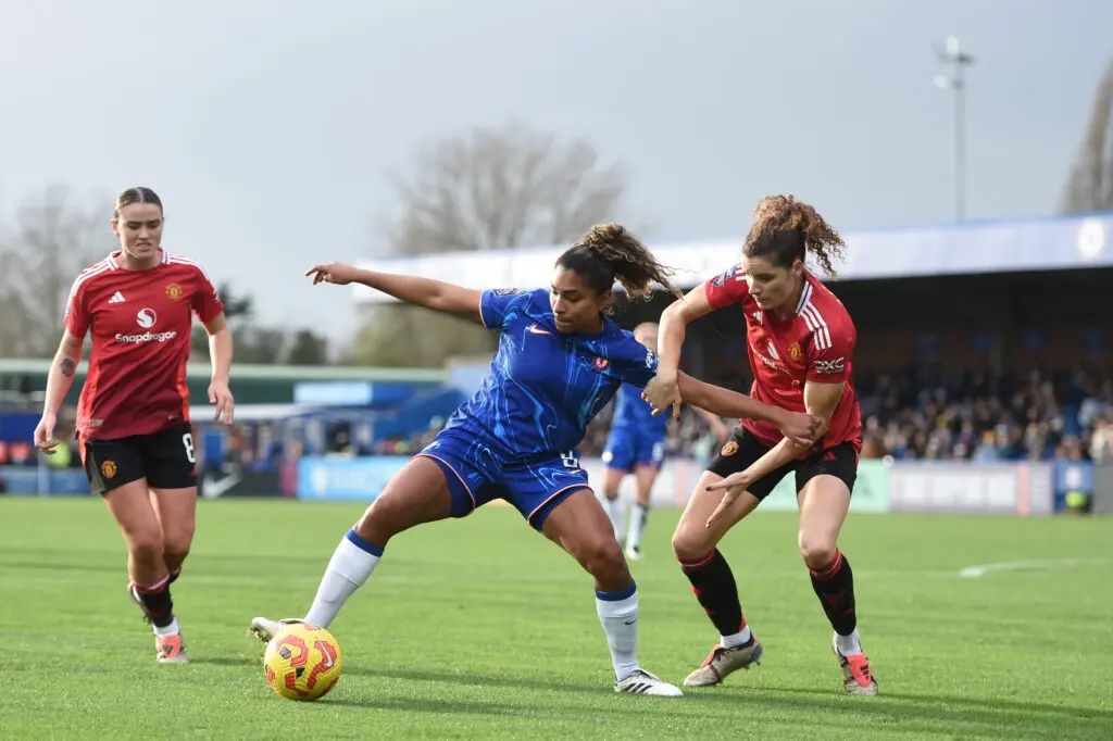 Manchester United's Dominique Janssen challenges Chelsea FC's Catarina Macario during a 2024/25 WSL match.