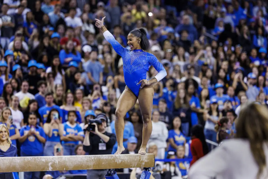 UCLA gymnastics star Jordan Chiles poses during her balance beam routine at a 2025 NCAA meet.