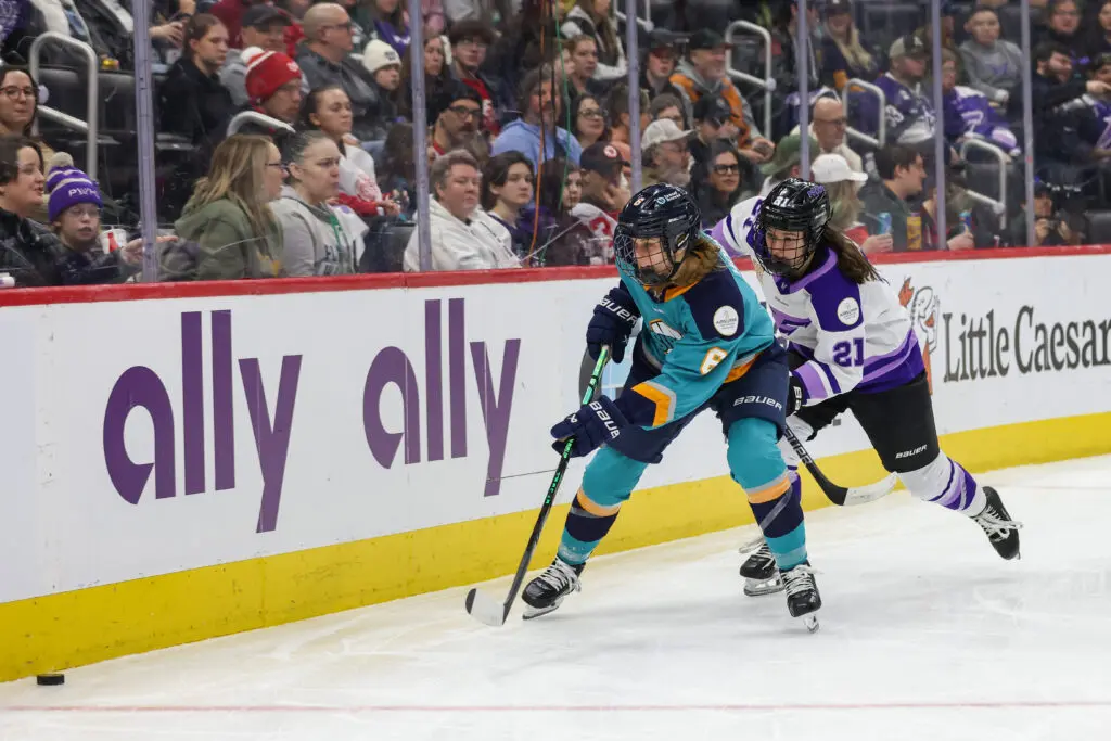 New York's Brooke Hobson and Minnesota's Liz Schepers chase the puck during a 2025 PWHL Takeover Tour game.