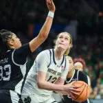 Transfer portal entrant Kate Koval #13 of the University of Notre Dame is defended by Trinity Moore #33 of Stephen F. Austin State University during the First Round of the 2025 NCAA Women's Basketball Tournament.