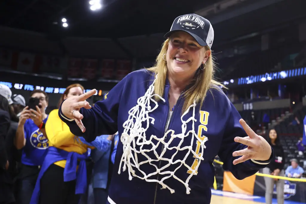 Naismith Coach of the Year award winner Coach Cori Close of the Big Ten UCLA Bruins gestures after cutting down the net after a game.