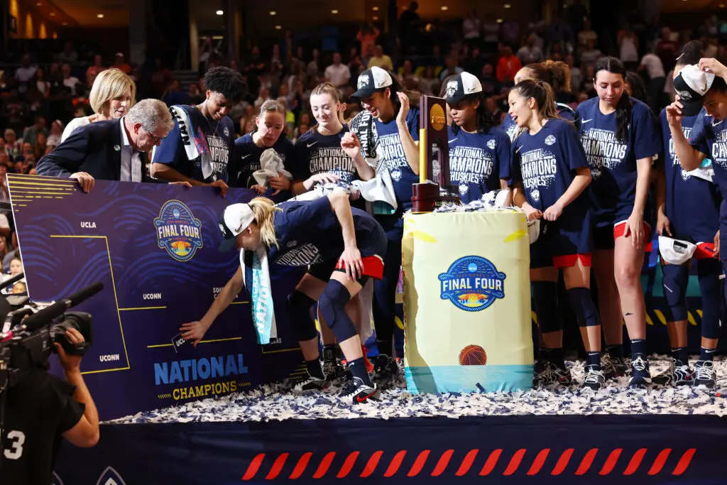 UConn star Paige Bueckers slaps the team's name in the championship spot after defeating South Carolina in Sunday's 2024/25 NCAA basketball title game.