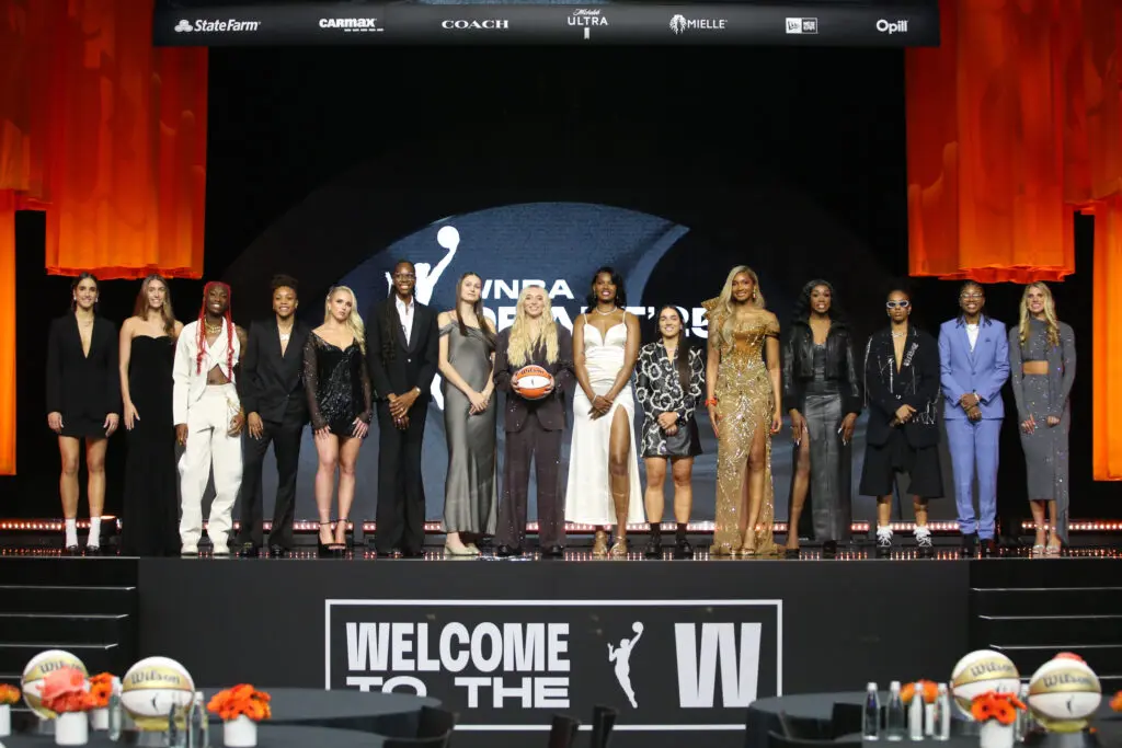 The 2025 WNBA Draft class including Washington Mystics rookies Kiki Iriafen and Sonia Citron poses on stage after the event.