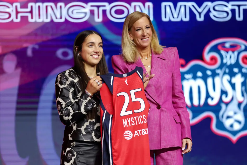 Teammate of Kiki Iriafen and Sonia Citron Georgia Amoore holds a Washington Mystics jersey with commissioner Cathy Engelbert after being selected No. 6 in the 2025 WNBA Draft.