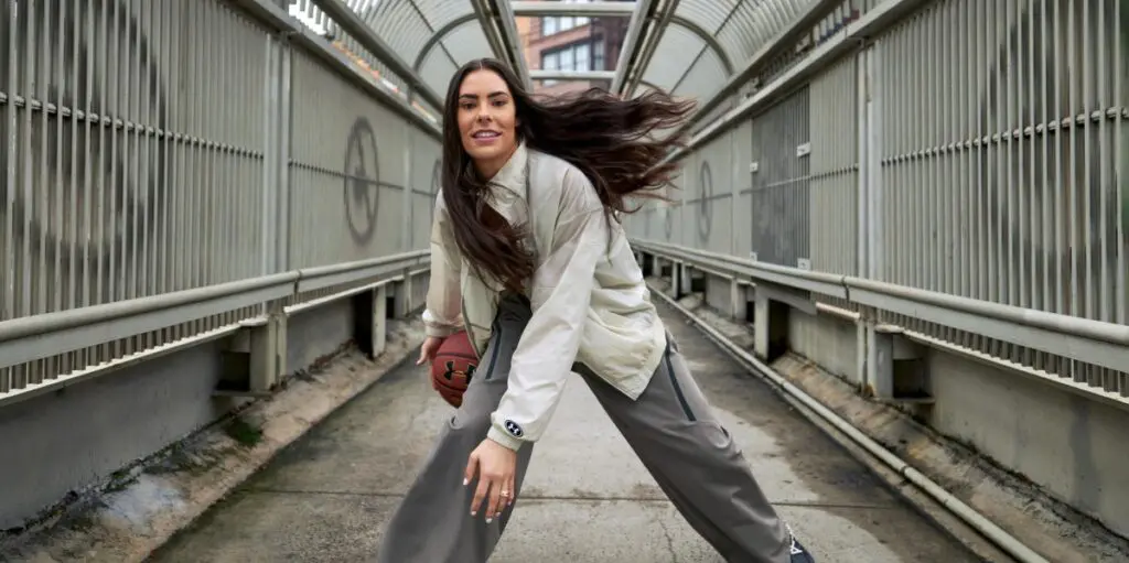 WNBA star Kelsey Plum dribbles a basketball wearing Under Armour fashion.