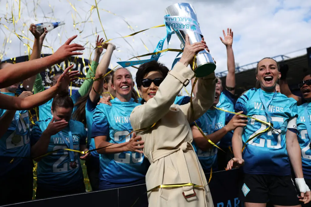 Owner Michele Kang lifts the Championship trophy and celebrates promotion with the London City Lionesses on Sunday.