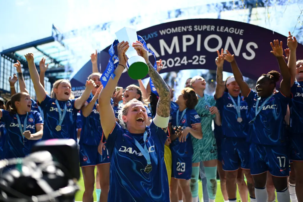 Millie Bright raises Chelsea's 2024/25 WSL trophy and celebrates with her teammates.