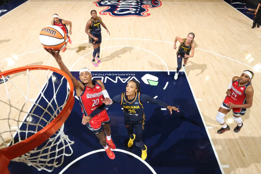 Washington's Brittney Sykes lays up a shot during a 2025 WNBA game while teammate Aaliyah Edwards and Indiana's DeWanna Bonner, Lexie Hull, and Aliyah Boston look on.