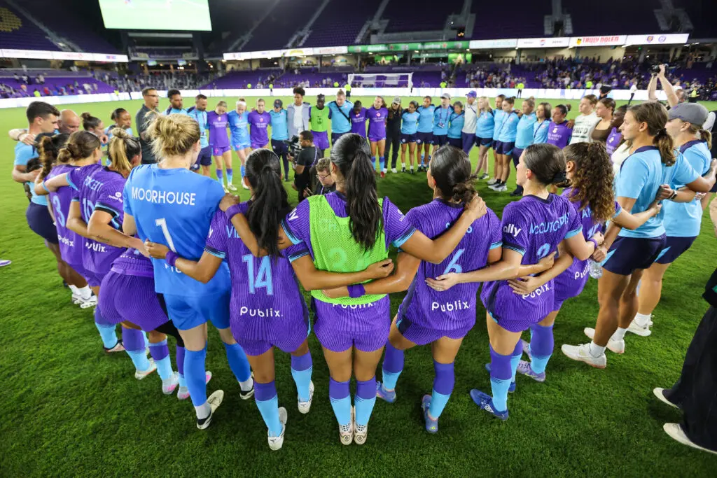 Orlando Pride players huddle before a 2025 NWSL match.