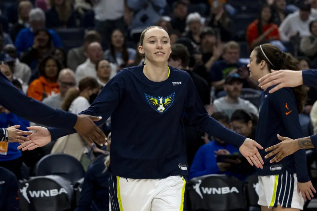 Dallas Wings guard Paige Bueckers high-fives her teammates as she is announced before a 2025 WNBA game.