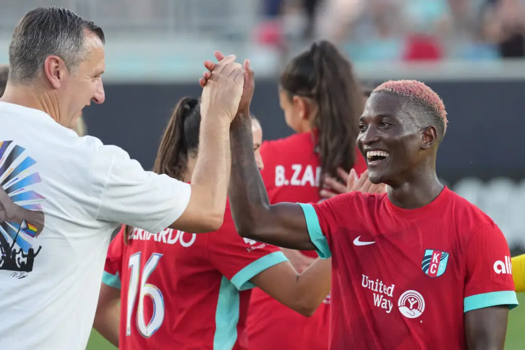 Kansas City striker Temwa Chawinga and head coach Vlatko Andonovski high-five after a 2025 NWSL victory.
