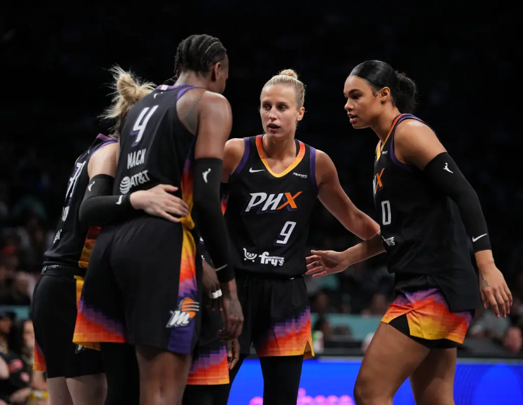 Phoenix Mercury players including Satou Sabally huddle during a 2025 WNBA game against the New York Liberty.