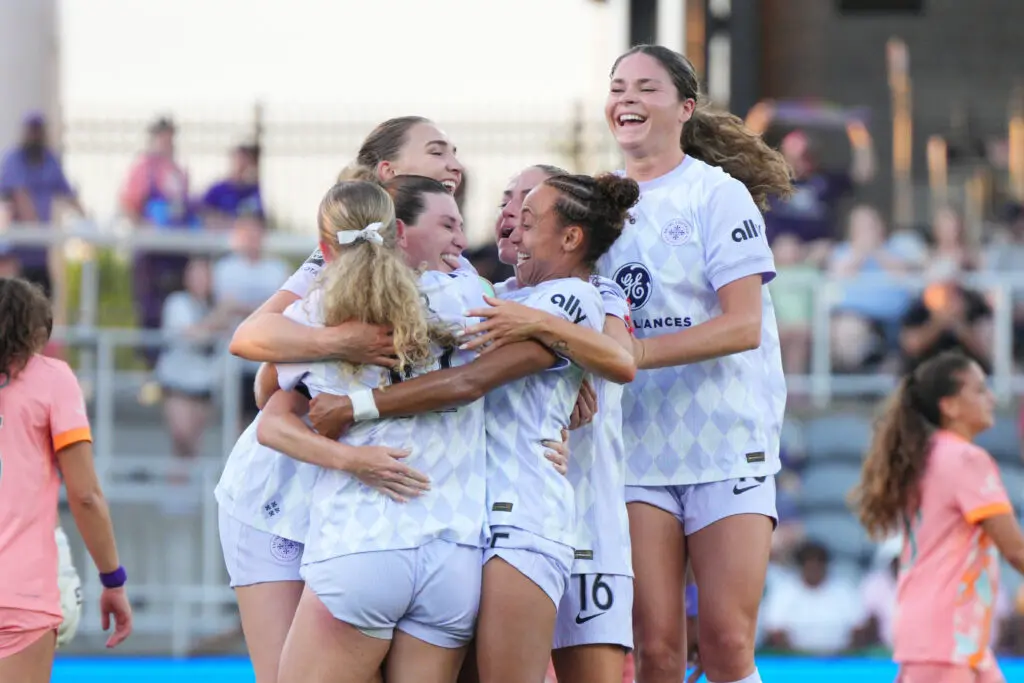 Racing Louisville teammates celebrate a goal by Arin Wright during a 2025 NWSL match.