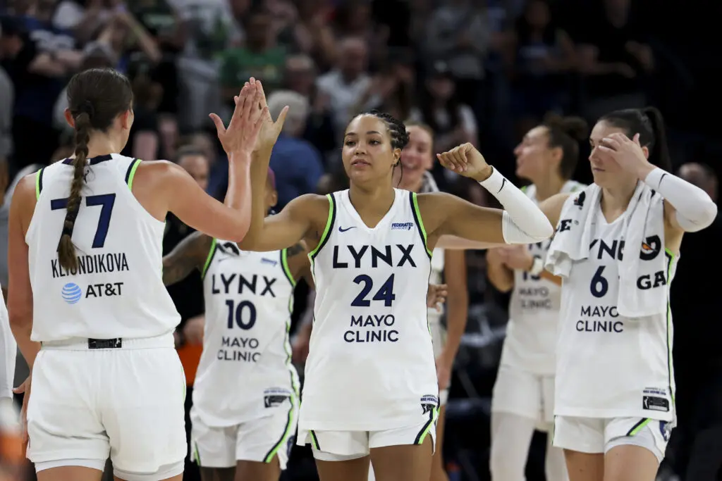 Naphees Collier high-fives her Minnesota Lynx teammates after a 2025 WNBA win.