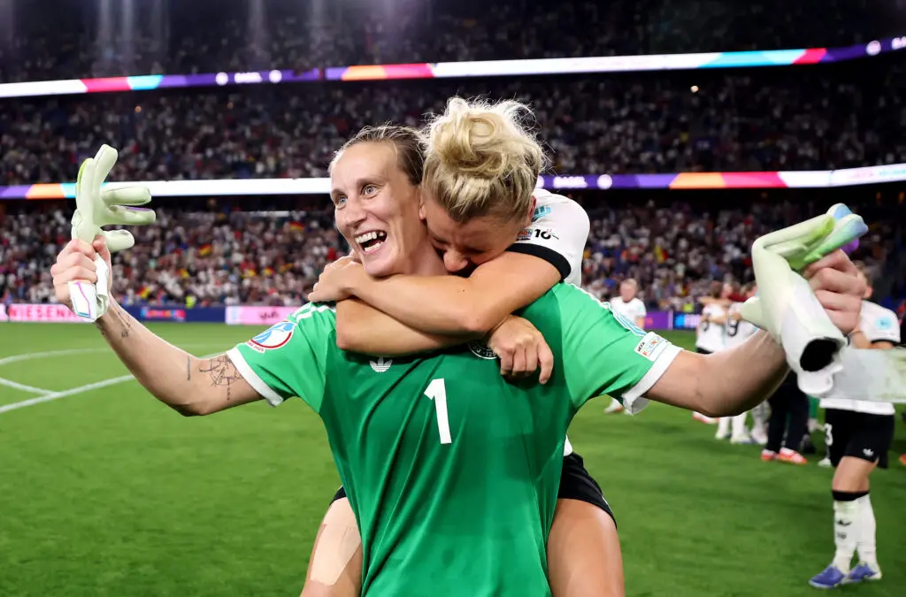Germany's Linda Dallmann hugs goalkeeper Ann-Katrin Berger after winning their 2025 Euro quarterfinal on penalty kicks.