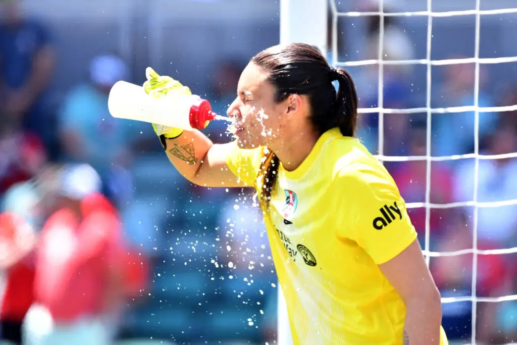 Kansas City Current goalkeeper Lorena splashes water on her face during a 2025 NWSL match.