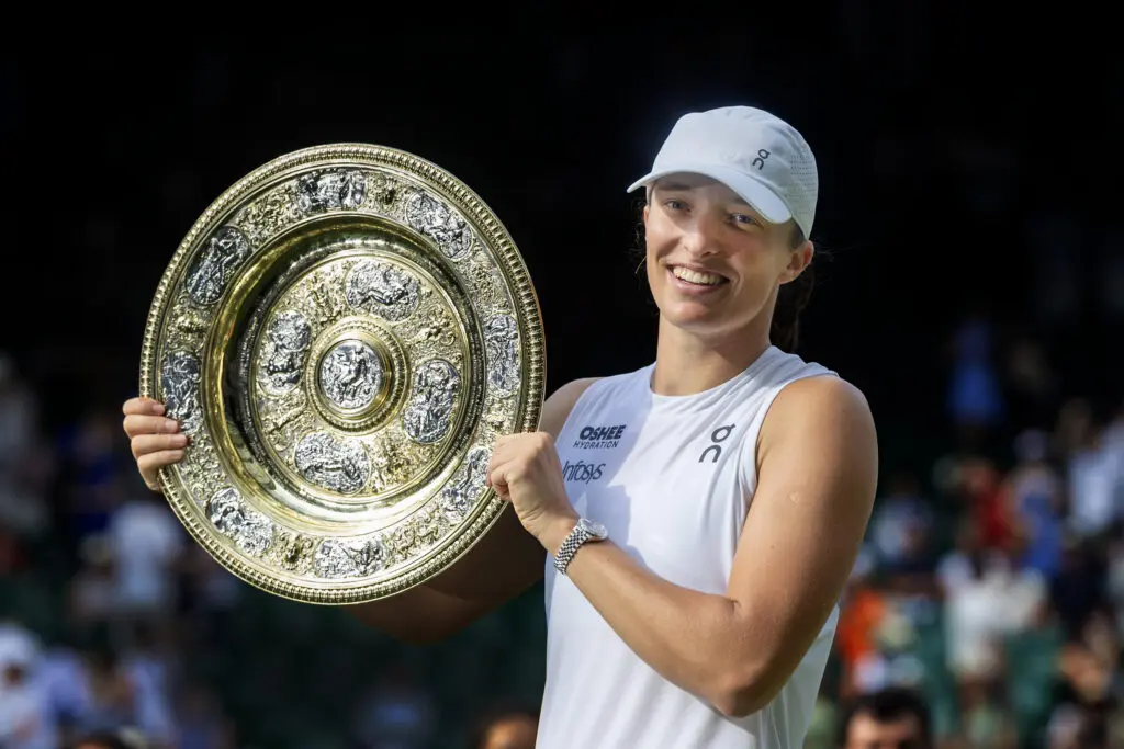 Poland tennis star Iga Świątek holds her 2025 Wimbledon trophy.