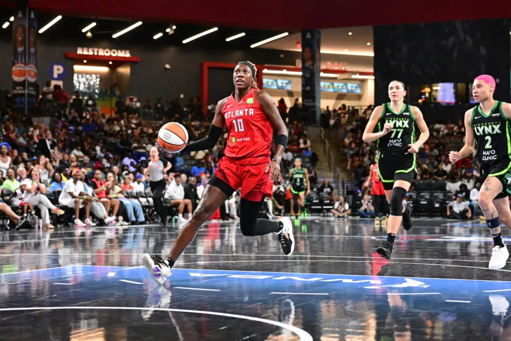 Atlanta Dream guard Rhyne Howard drives to the basket as Minnesota Lynx forward Maria Kliundikova and guard Natisha Hiedeman give chase during a 2025 WNBA game.