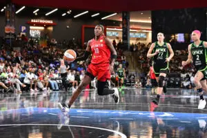 Atlanta Dream guard Rhyne Howard drives to the basket as Minnesota Lynx forward Maria Kliundikova and guard Natisha Hiedeman give chase during a 2025 WNBA game.