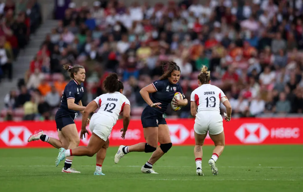 Team USA star Ilona Maher carries the ball as England centers Tatyana Heard and Meg Jones go in for the tackle during the opening game at the 2025 Women's Rugby World Cup.
