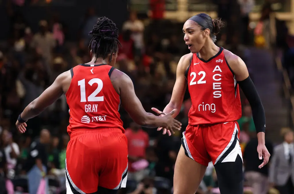 Las Vegas Aces center A'ja Wilson and guard Chelsea Gray high-five during a 2025 WNBA game.