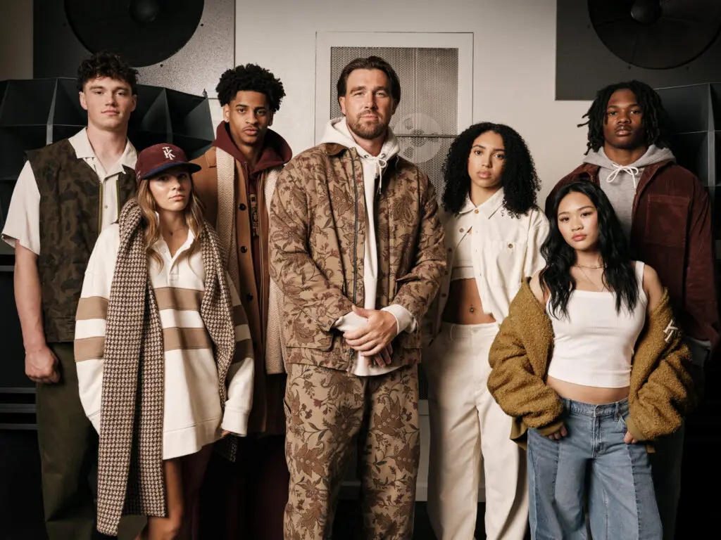Athletes Anna Frey, Azzi Fudd, Drew Allar, Jeremiah Smith, Kiyan Anthony, Suni Lee, and Travis Kelce pose wearing the AE x Tru Kolors by Travis Kelce collection.