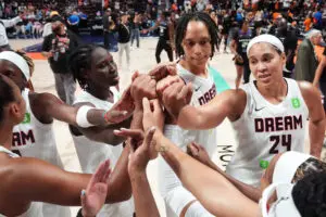 The Atlanta Dream huddles after a 2025 WNBA win.