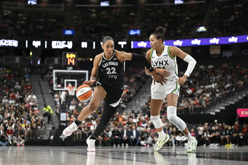 Las Vegas Aces center A'ja Wilson drives to the basket past Minnesota Lynx forward Napheesa Collier during a 2025 WNBA game.