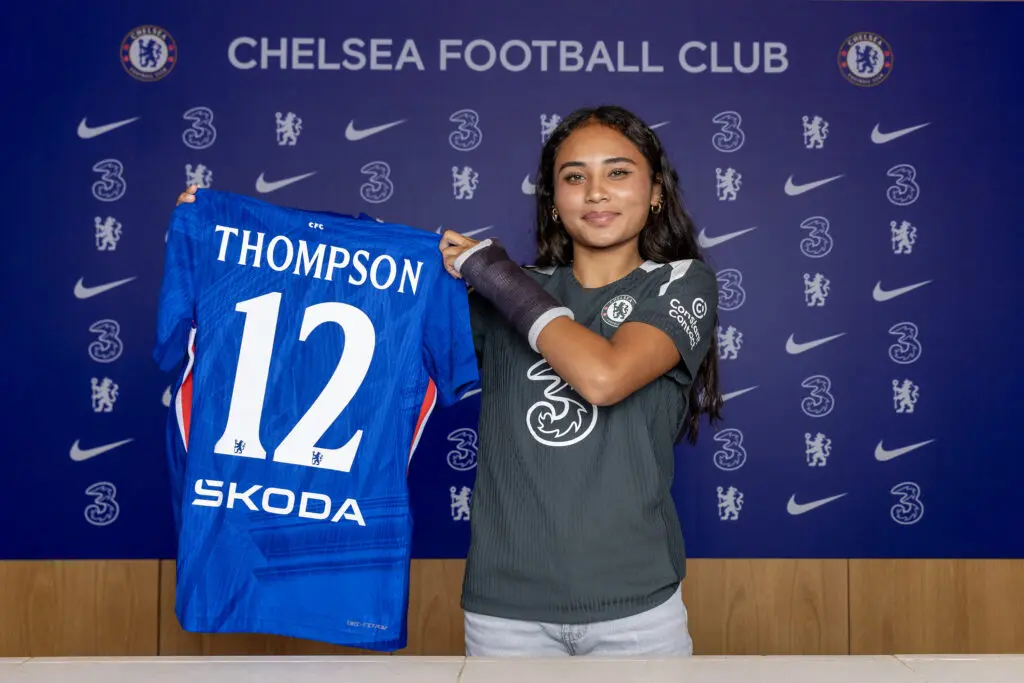 USWNT forward Alyssa Thompson poses holding a Chelsea FC jersey after her 2025 signing with the WSL club.