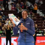 Connecticut Sun star Tina Charles flashes a big smile after receiving her Dawn Staley Community Leadership Award before a 2025 WNBA game.