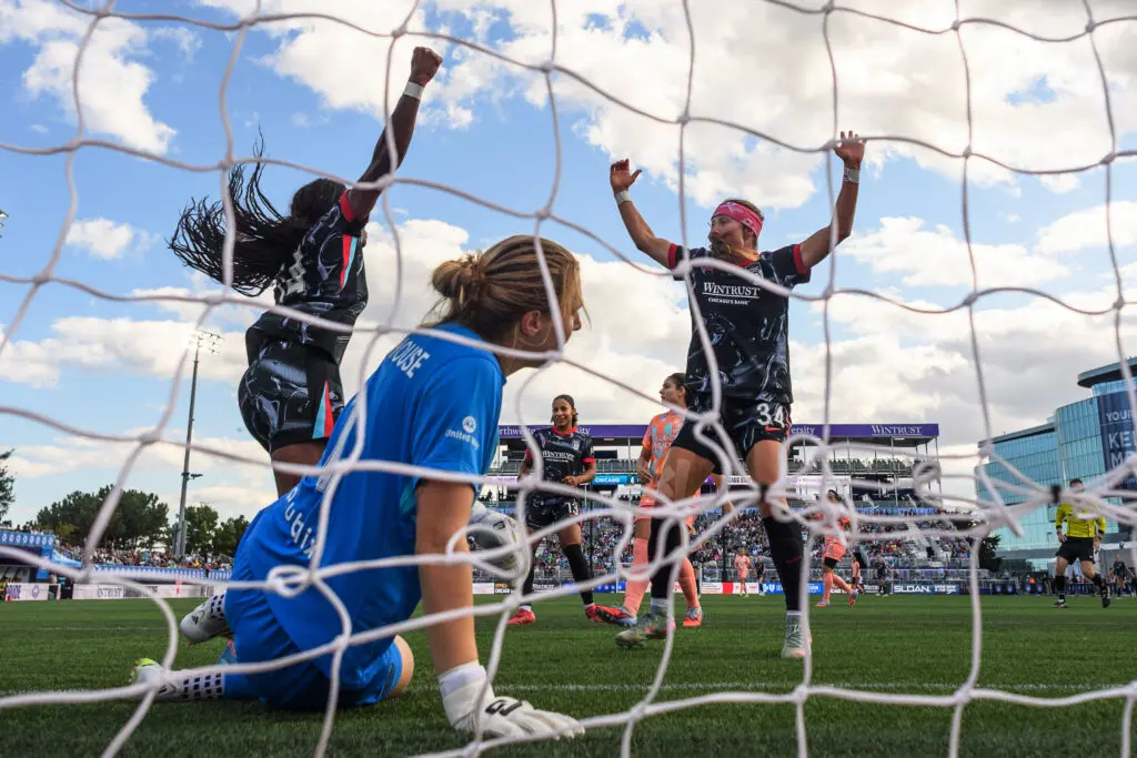 Orlando Pride goalkeeper Anna Moorhouse watches from the ground as Chicago Stars forwards Ludmila and Ally Schlegel celebrate a goal during a 2025 NWSL match.