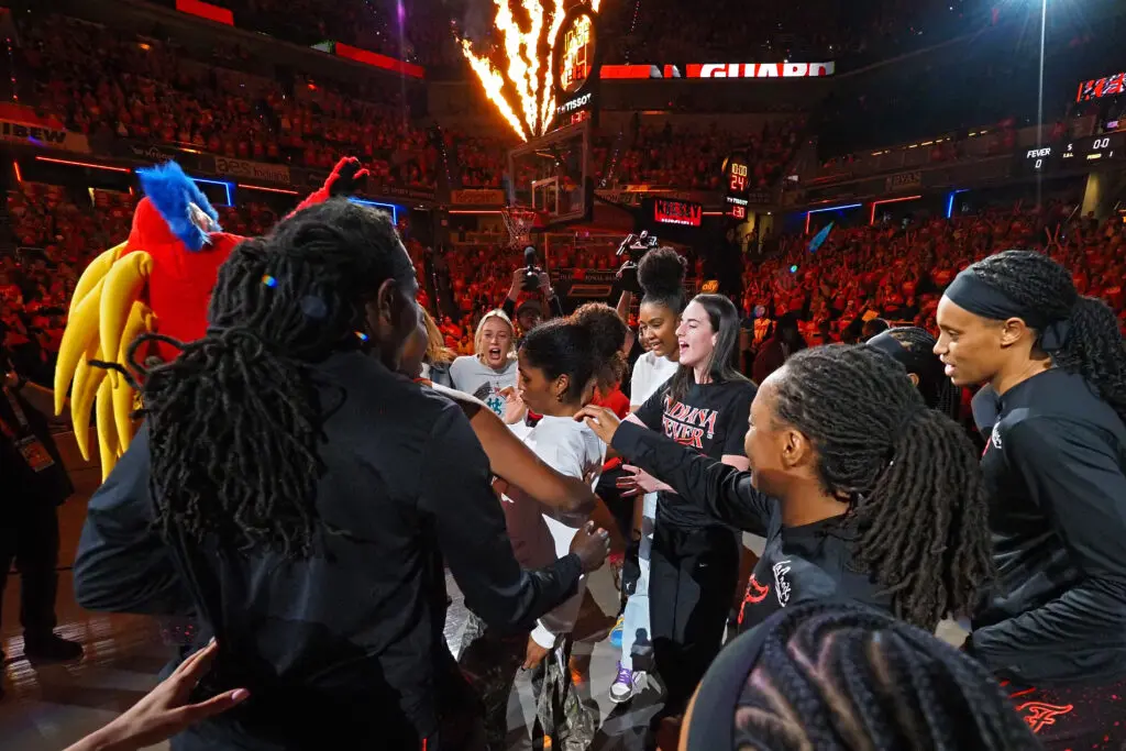 Indiana Fever players hype each other up in a pre-game huddle in Indianapolis during the first round of the 2025 WNBA Playoffs.