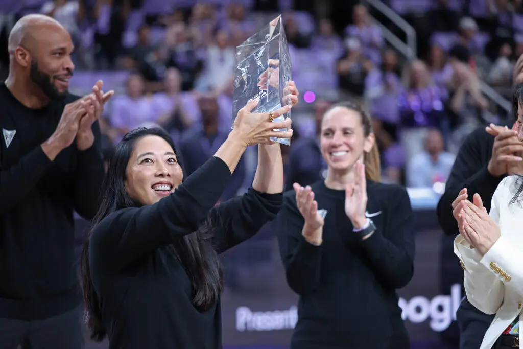 Golden State Valkyries boss Natalie Nakase lifts her 2025 WNBA Coach of the Year trophy before a playoff game.