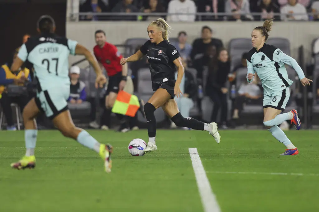 Angel City rookie forward Riley Tiernan dribbles the ball away from Gotham defenders Emily Sonnett and Jess Carter during a 2025 NWSL match.