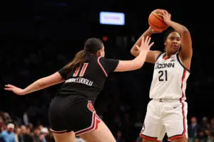 UConn basketball star Sarah Strong looks to pass the ball during a December 2024 NCAA game.