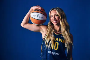 Indiana Fever guard Lexie Hull poses holding a basketball at the 2025 WNBA Media Day.
