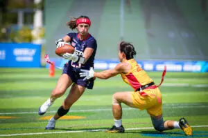 Team USA wide receiver Isabella Geraci runs around a Team China defender during a preliminary round flag football game at the 2025 World Games in Chengdu, China.