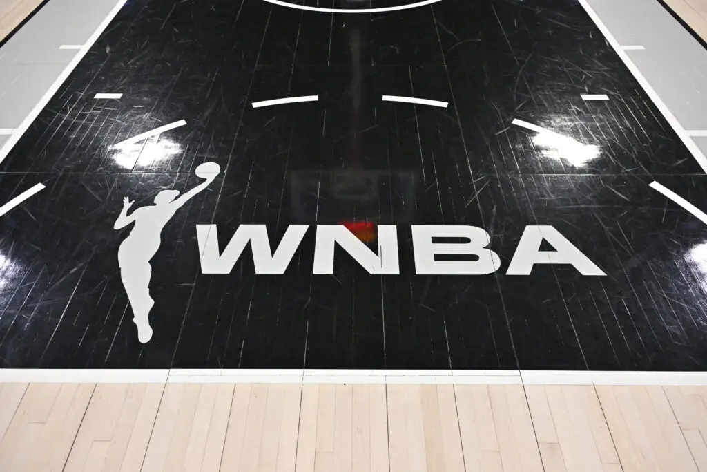 A close-up of the WNBA logo on the court before a 2025 game.