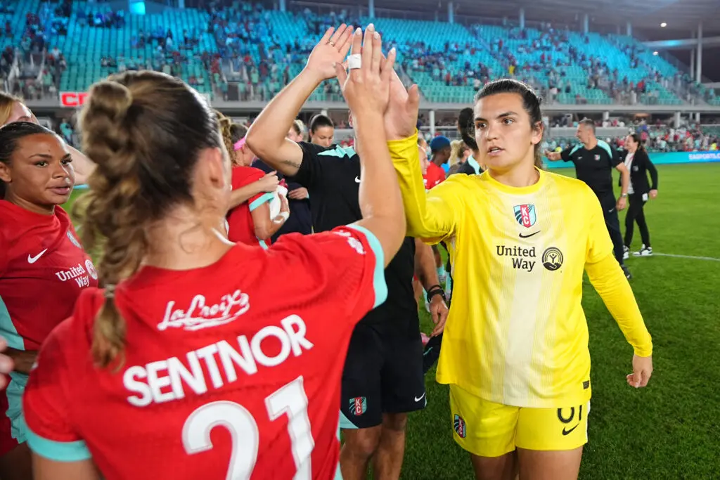 Kansas City Current forward Ally Sentnor and goalkeeper Laurel Ivory high-five after a 2025 NWSL match.