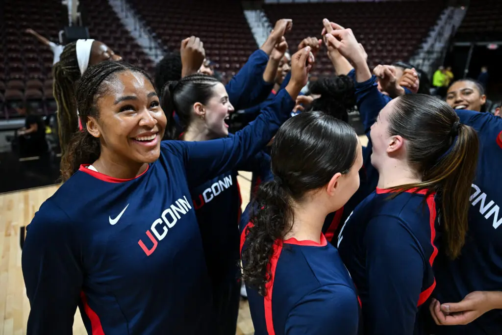 UConn forward Sarah Strong smiles as the Huskies huddle before a 2025 preseason NCAA basketball exhibition game.